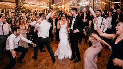 Ein Hochzeitspaar ist umgeben von Gästen, die einen Flashmob gestartet haben und wild tanzen.