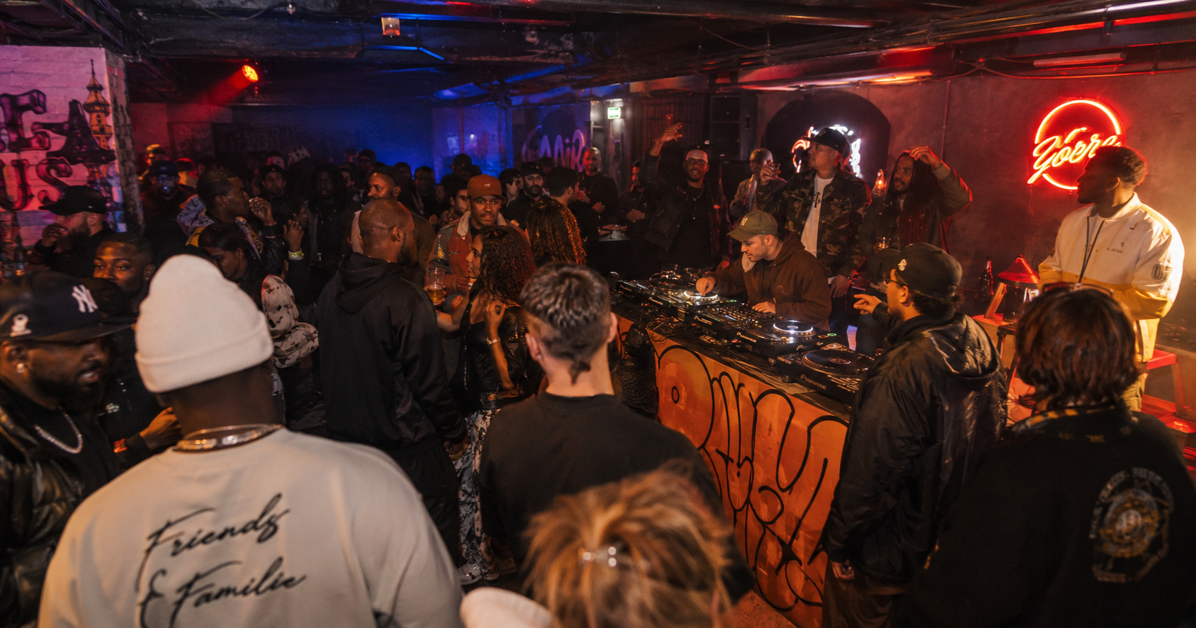 Eine Gruppe von jungen Menschen feiert eine Hip-Hop-Party im Underground-Setting.